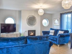 a living room with blue couches and a tv at Nicosia House with sea views. in Westward Ho