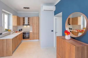 a kitchen with a mirror and a vase of flowers on a counter at St Jakov Superior Beach Apartment with Free Parking in Dubrovnik
