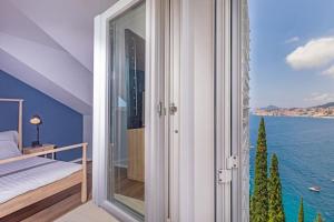 a bedroom with a view of the ocean at St Jakov Superior Beach Apartment with Free Parking in Dubrovnik