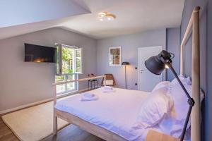 a bedroom with a bed and a lamp in it at St Jakov Superior Beach Apartment with Free Parking in Dubrovnik