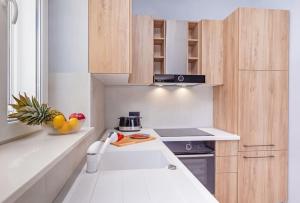 a small white kitchen with a counter top and a sink at St Jakov Superior Beach Apartment with Free Parking in Dubrovnik