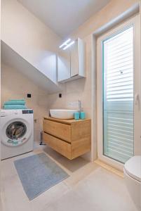 a bathroom with a sink and a washing machine at St Jakov Superior Beach Apartment with Free Parking in Dubrovnik
