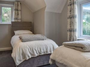 a bedroom with two beds and a window at Nicosia House with sea views. in Westward Ho