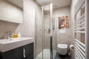 y baño con ducha, lavabo y aseo. en Superbe F1 avec terrasse et parking privé, en Évian-les-Bains