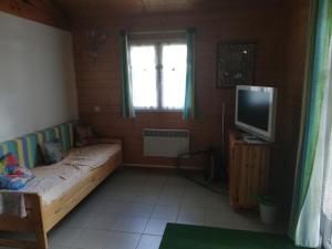 a small room with a bed and a television at Au Soleil de Picardie in Presles-et-Boves