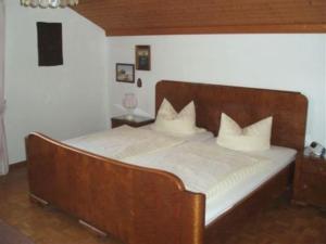 a bed with a wooden headboard in a bedroom at Haus Fiedler in Piding