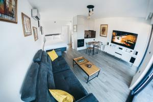HelloSky Apartment في موستار: غرفة معيشة بها أريكة وطاولة