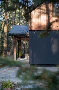 un edificio de madera con un banco frente a los árboles en Domek z SAUNĄ na leśnej działce w Wildze, en Wilga