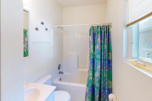 a white bathroom with a shower curtain and a sink at Captain's Deck in Ocean City +9 photos