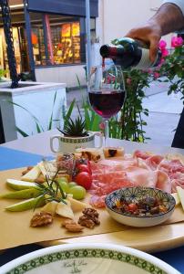 a person pouring a glass of wine on a cutting board at Hotel Villa Lina in Riccione