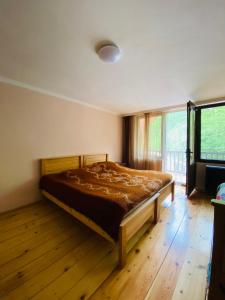 a bedroom with a bed in a room with a window at Likani house in Borjomi
