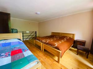 a bedroom with a bed and a wooden floor at Likani house in Borjomi