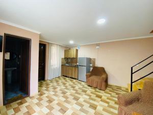 a living room with a kitchen with a refrigerator at Likani house in Borjomi +18 photos