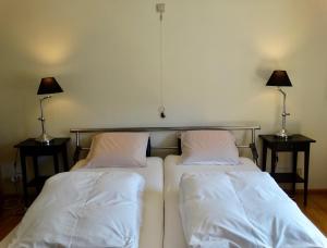 2 Betten in einem Zimmer mit 2 Lampen an Tischen in der Unterkunft BENVENUTI in Saint-Idesbald