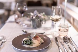 a plate of food on a table with wine glasses at Hotel Pirchnerhof in Reith im Alpbachtal