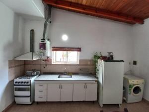 eine Küche mit einem Herd, einer Spüle und einem Kühlschrank in der Unterkunft LA SERRANITA - Frente al Rio in Río Ceballos + 15 Fotos