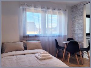 um quarto com uma cama e uma mesa com cadeiras em Cosy Case proche Disney and Paris em Lagny