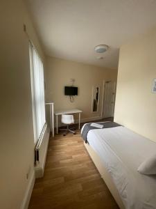 a bedroom with a bed and a desk in it at Mersey view Hotel & Pub in Hale