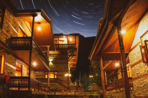 een nachtzicht op een gebouw met trappen en verlichting bij Shivadya - A Boutique Hotel in Manāli