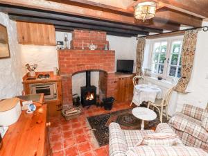 a living room with a brick fireplace and a table at Old Blacksmiths Cottage in Market Rasen