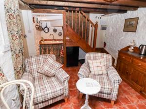 a living room with two chairs and a table at Old Blacksmiths Cottage in Market Rasen