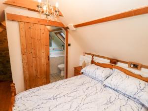 a bedroom with a bed and a bathroom at Old Blacksmiths Cottage in Market Rasen