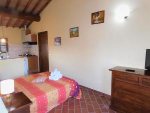 a bedroom with a bed and a dresser and a kitchen at Agriturismo Terre di Toscana in Terricciola