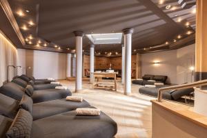 a salon with a row of couches and a table at Hotel Pirchnerhof in Reith im Alpbachtal