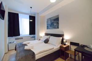 una camera con un letto bianco e una grande finestra di Hotel U Ševce a Zlín
