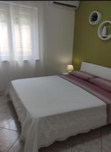 a white bed in a room with a window at Appartamento Panorama sul mare in Tropea