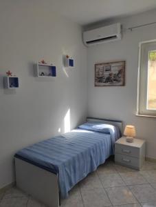 ein Schlafzimmer mit einem Bett mit einer blauen Decke in der Unterkunft Appartamento Panorama sul mare in Tropea