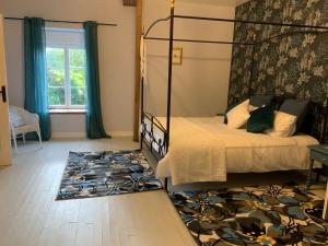 1 dormitorio con cama con dosel y alfombra en Welcoming and peaceful bed and breakfast, en Fougerolles-du-Plessis