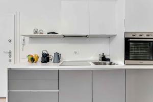 een witte keuken met een wastafel en een magnetron bij New Milan Central Apartment in Milaan