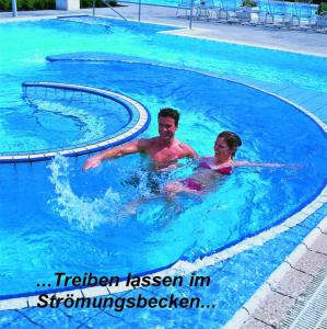 un uomo e una donna in una piscina di Pension Schneider, Bad Gögging a Neustadt an der Donau