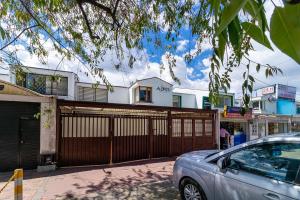 a car parked in front of a house with a fence at Ayenda 1079 Bogotá Alpes Polo Club in Bogotá