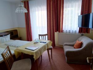 una camera con tavolo, letto e divano di Pension Schneider, Bad Gögging a Neustadt an der Donau