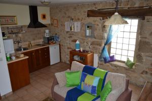 a living room with a couch and a kitchen at La Fuente in Umbrías