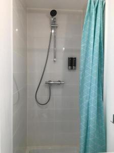 a shower with a blue shower curtain in a bathroom at Le Bahia centre la Brèche wifi linge de pressing in Niort