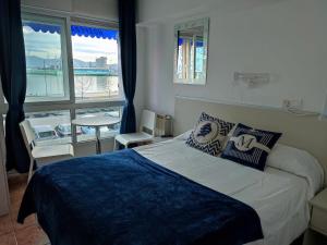 Dormitorio con cama y vistas al agua en Hostal Lucy, en Santander