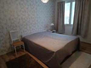 a bedroom with a bed and a chair and a window at FirstHome GuestHouse in Pietarsaari