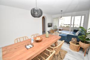 een woonkamer met een houten tafel en stoelen bij Expoholidays - Apartamentos Puerto Almerimar in Almerimar