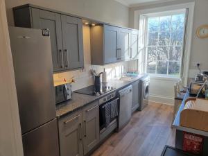 a kitchen with stainless steel appliances and a large window at Park View Two-Bedroom Apartment in Bath