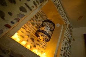 una jaula de pájaro colgando de una pared con una luz en Le repère, pour fan de sorcellerie !, en Pau