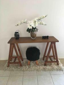 a wooden table with a vase of flowers on it at Casa em bairro nobre, bem localizada, com suite. in Bento Gonçalves