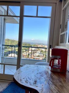 uma máquina de café sentada numa mesa em frente a uma janela em Casa em bairro nobre, bem localizada, com suite. em Bento Gonçalves