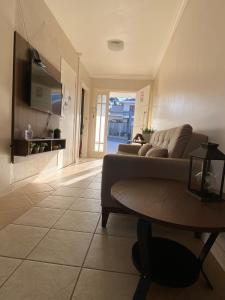 a living room with a couch and a table at Casa em bairro nobre, bem localizada, com suite. in Bento Gonçalves