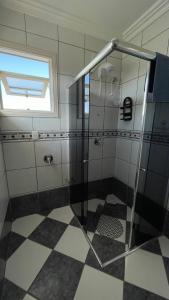 a shower with a glass door in a bathroom at Casa em bairro nobre, bem localizada, com suite. in Bento Gonçalves +13 photos