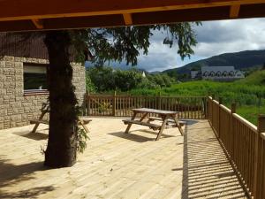 a wooden deck with a picnic table and a tree at Carn Mhor Bed and Breakfast in Aviemore