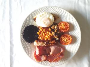 a plate of food with meat and beans and ice cream at Carn Mhor Bed and Breakfast in Aviemore