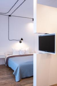 a bedroom with a bed and a flat screen tv at Check in Szczecin in Szczecin